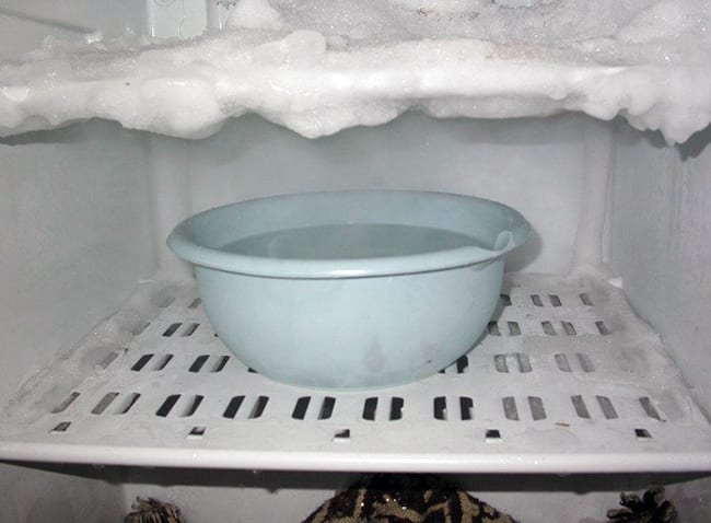 Размораживание морозильной камеры при помощи кастрюли с кипятком