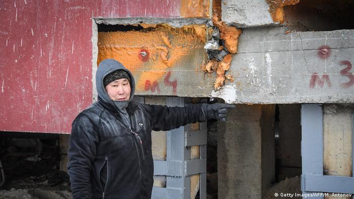 Construction worker Eduard Romanov points to a spot on a cracked panel building in eastern Siberia (Getty Images/AFP/M. Antonov)